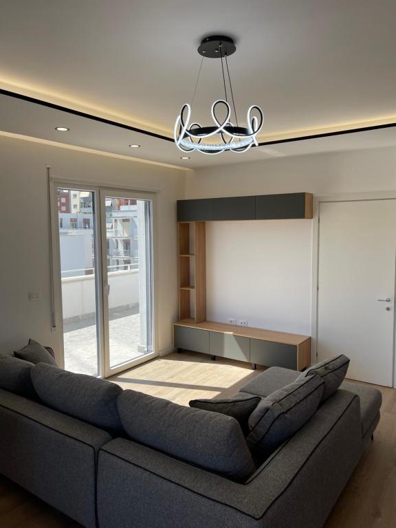 un salon avec un canapé et un lustre dans l'établissement For rent apartament 160m Unaza e re, à Tirana