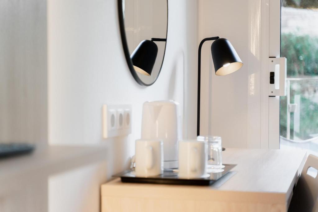 a table with a mirror and a lamp on it at Minura Cala Galdana & Apartamentos d'Aljandar in Cala Galdana