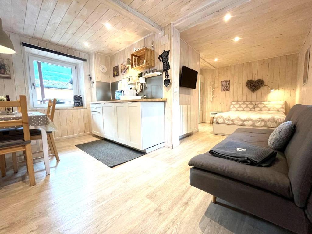 a living room with a couch and a table and a kitchen at Due cuori e... un Loft nel cuore antico di Aosta in Aosta