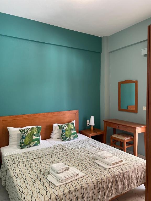 1 dormitorio con 1 cama con pared azul en Helios Apartments, en Plakias