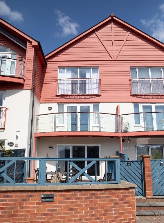 a red and white building with a balcony at At Watersedge in Exmouth