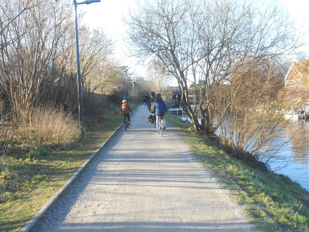 3 personnes voyageant en vélo sur un sentier à côté d'une rivière dans l'établissement Le Cèdre, à Cambron