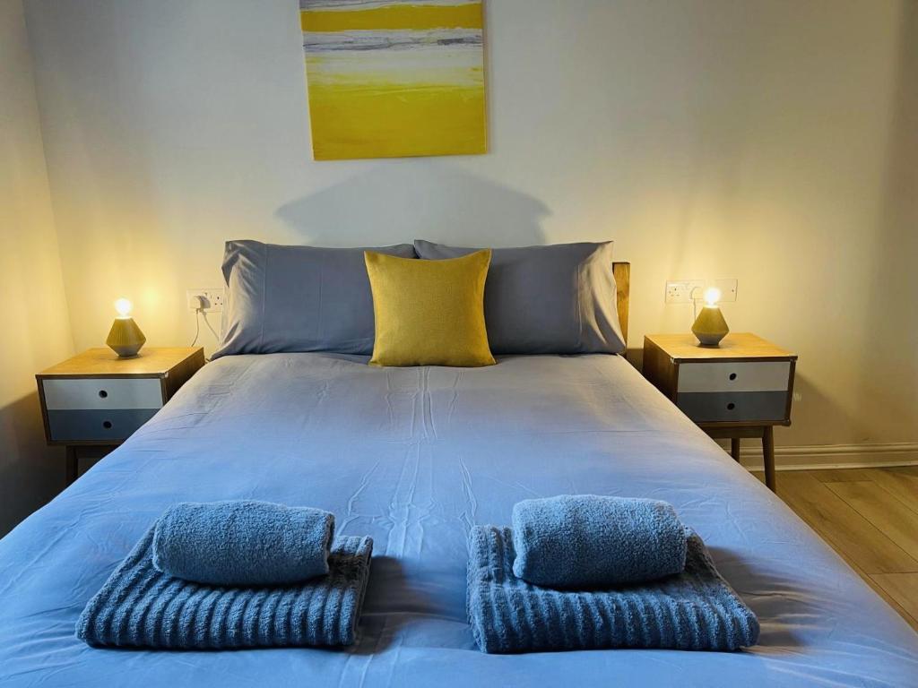 a blue bed with two pillows on it with two night stands at Spacious City Centre flat free parking& superfast WIFI in Edinburgh
