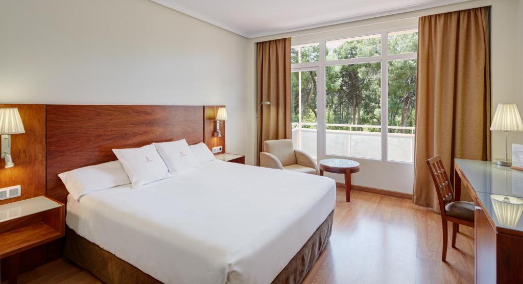 ein Hotelzimmer mit einem großen Bett und einem Fenster in der Unterkunft Sercotel Los Llanos in Albacete