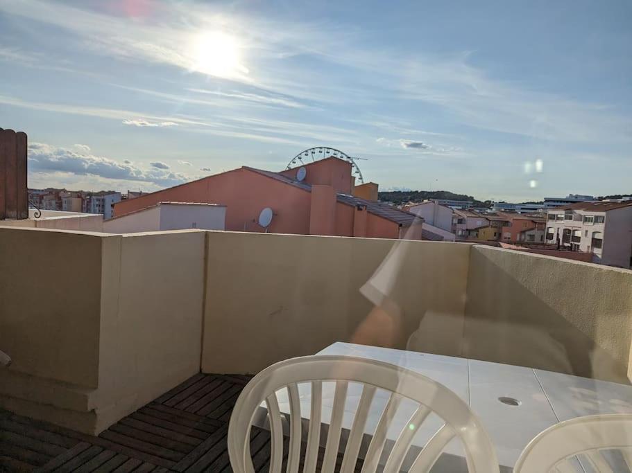 d'un balcon sur le toit avec une table et des chaises. dans l'établissement Studio Centre port Cap4, au Cap d'Agde