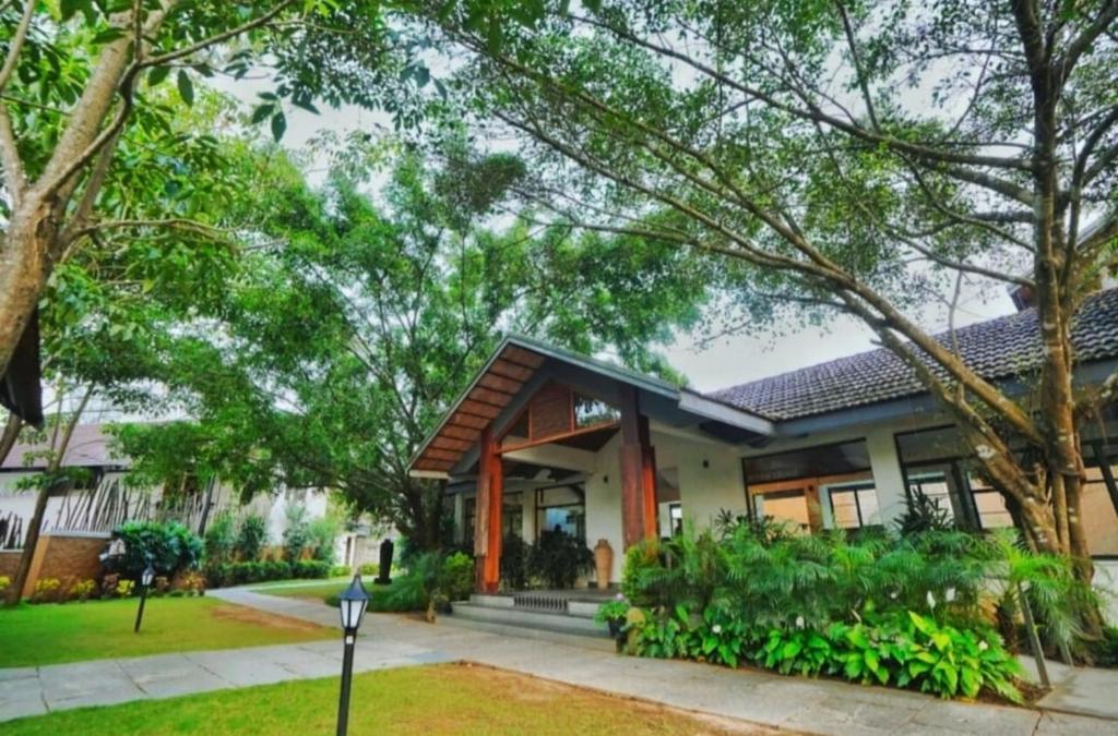 a house with a lot of windows and trees at Misty Grove Resort Hotel in Gūdalūr