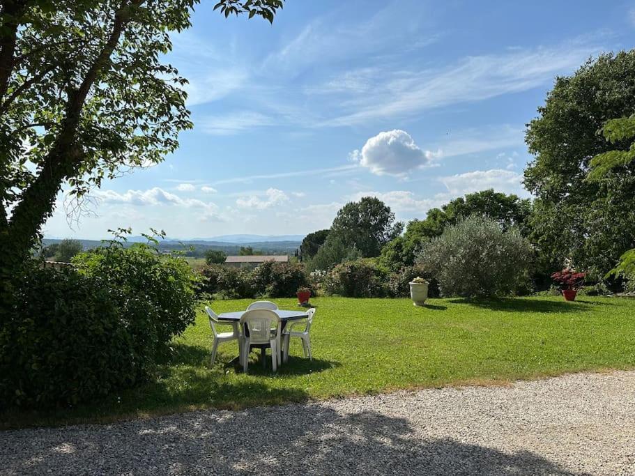 a table and chairs sitting in the grass at Maison au calme avec jardin in Brouzet-lès-Alès