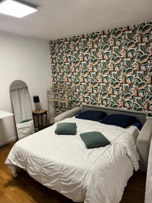 - une chambre avec un grand lit blanc et du papier peint dans l'établissement My House, à Choisy-le-Roi