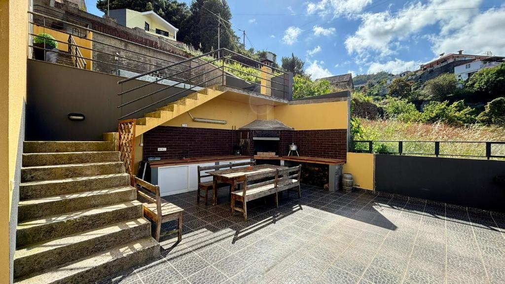 uma casa com um pátio com uma mesa e escadas em Ocean Hill House em Santa Cruz - Madeira
