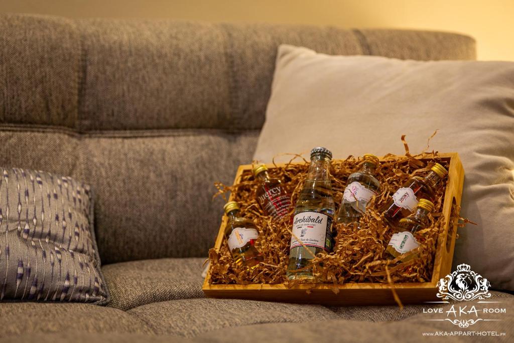 a basket of alcohol bottles on a couch at Prestige De Cocagne in Lavaur