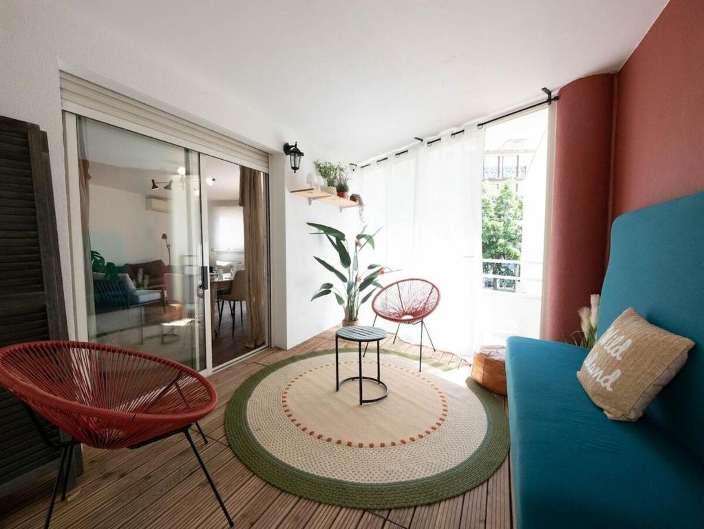 un salon avec un canapé, une table et des chaises dans l'établissement L'élégant - Terrasse et climatisation, à Montpellier