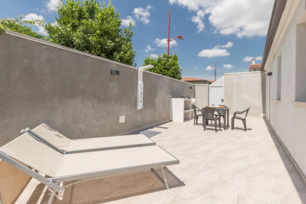 a patio with a table and chairs on a wall at Villino in centro con cortile interno, wifi e aria condizionata in Codigoro
