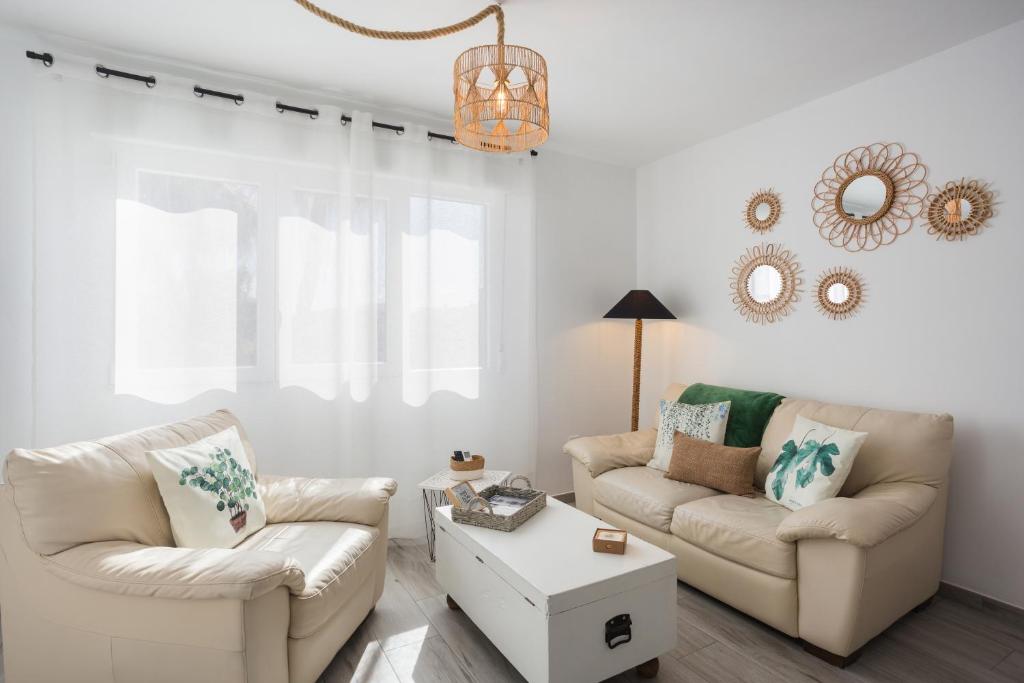a living room with two couches and a table at Apartamento Jávea Puerto in Jávea