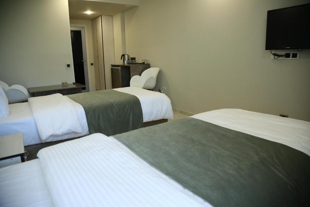 Postel nebo postele na pokoji v ubytování Vell Grey Hotel