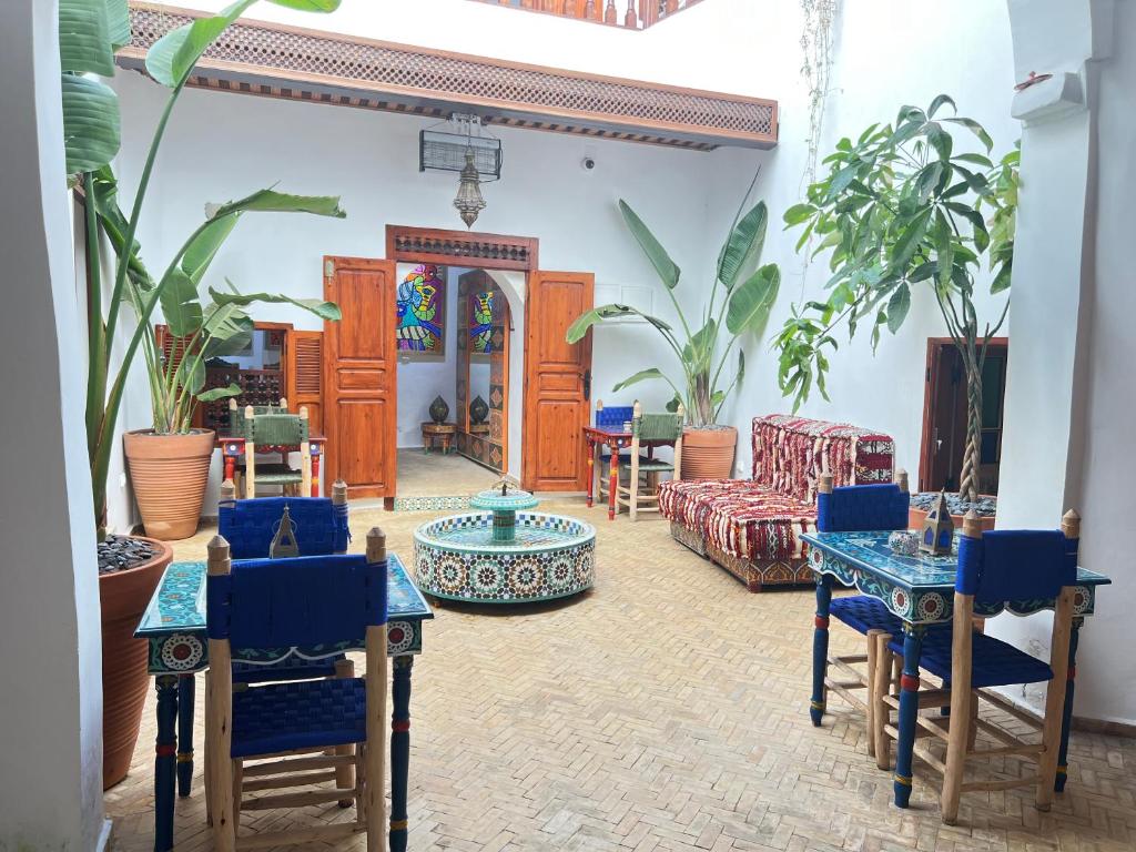 Dar Mounia في الرباط: غرفة معيشة مع كراسي زرقاء وطاولات ونباتات