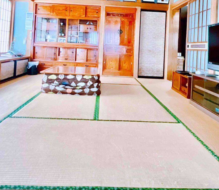 富士吉田的住宿－T&T Fujiyama Guest House，客厅配有桌子和电视