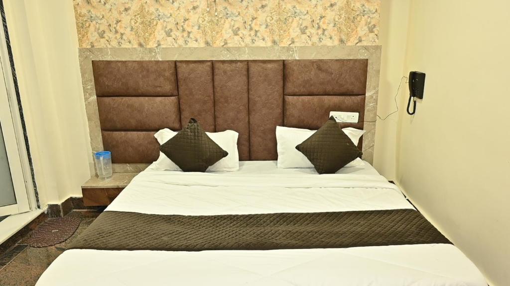 Un dormitorio con una cama grande con cabecero de madera. en Hotel Kaka Inn, en Ajmer