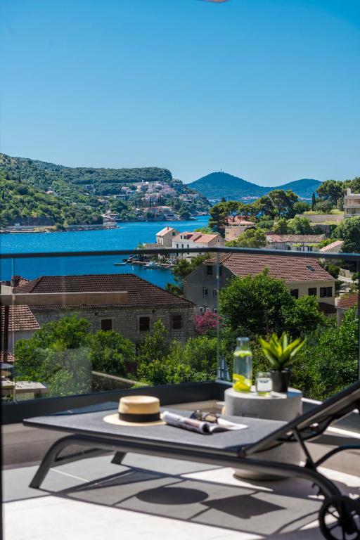 a table on a balcony with a view of the water at Azzurea Residence in Zaton