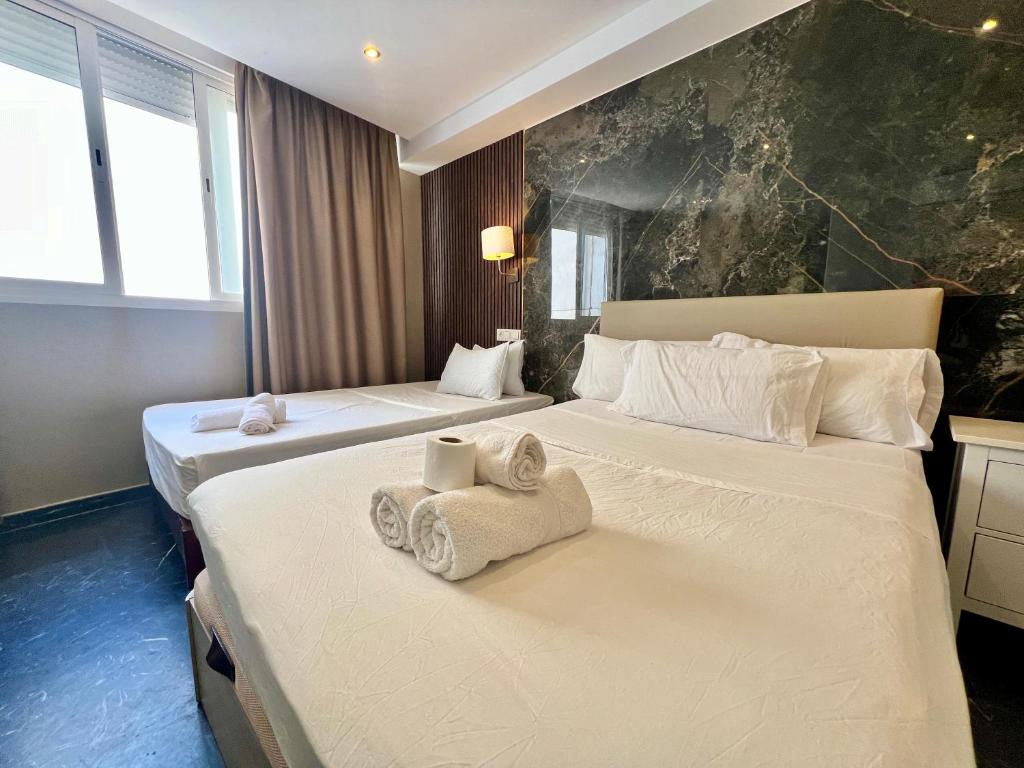 Dos camas en una habitación de hotel con toallas. en Costa Marbella Star Light en Marbella