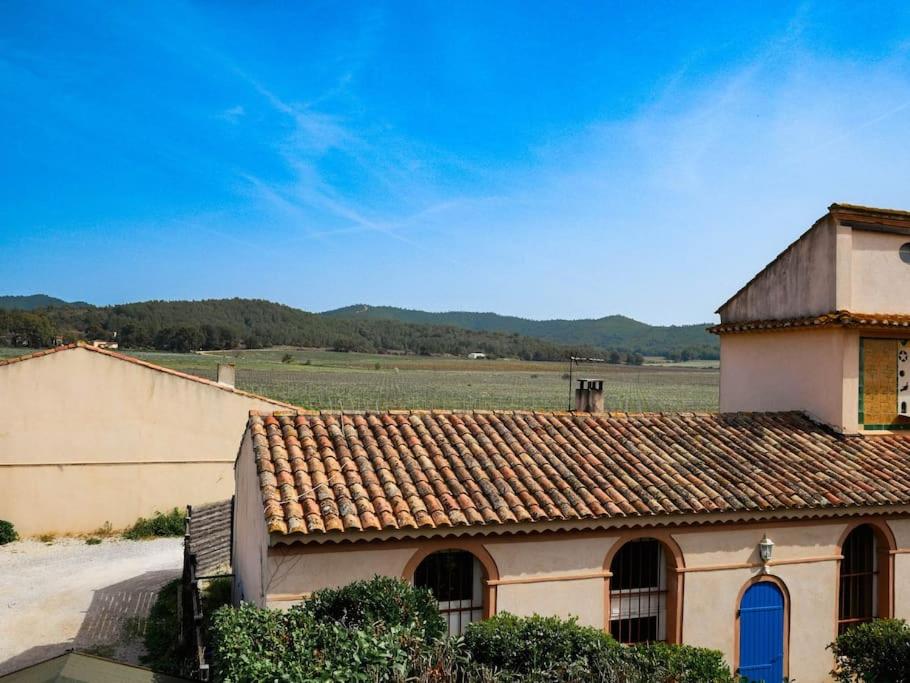 un bâtiment avec un toit en tuiles avec un champ en arrière-plan dans l'établissement Grand duplex de charme en pleine campagne, à Hyères
