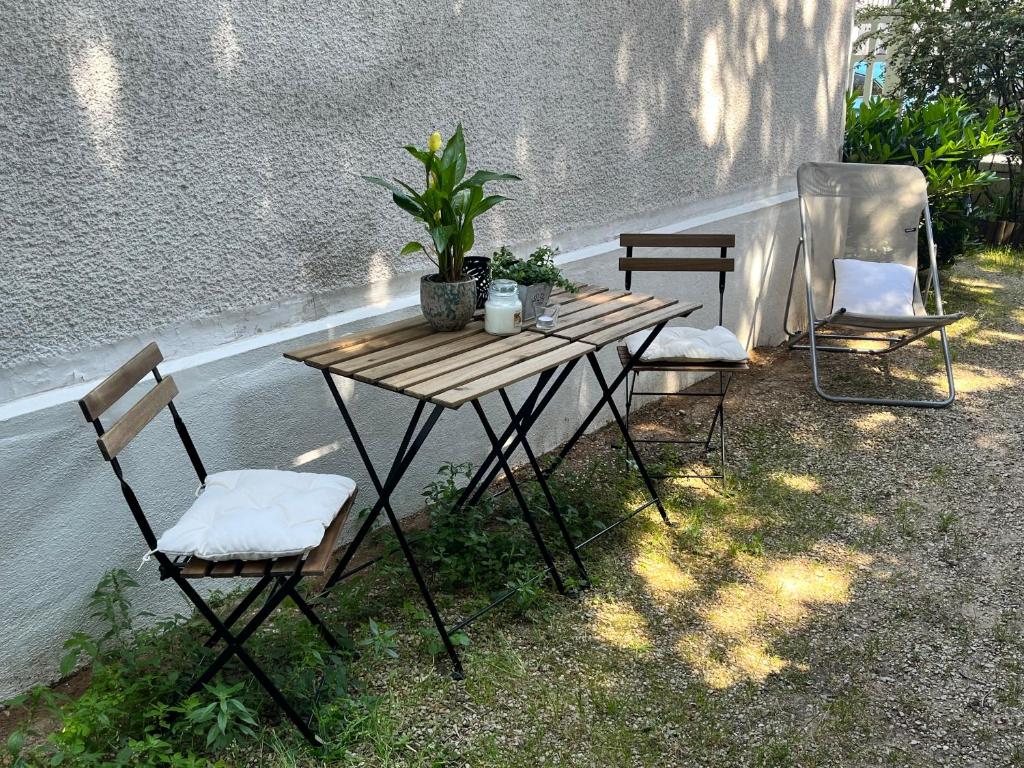 duas cadeiras e uma mesa de madeira e duas cadeiras em Chambre d'hôte - Gabriel em Saint-Maur-des-Fossés