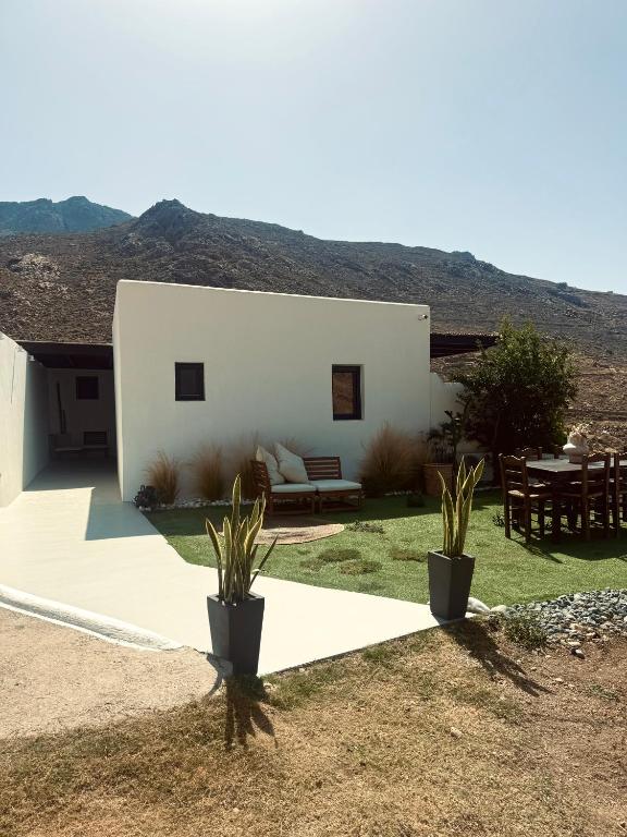 a white house with two potted plants in front of it at Vie rêvée luxury suites in Ganema