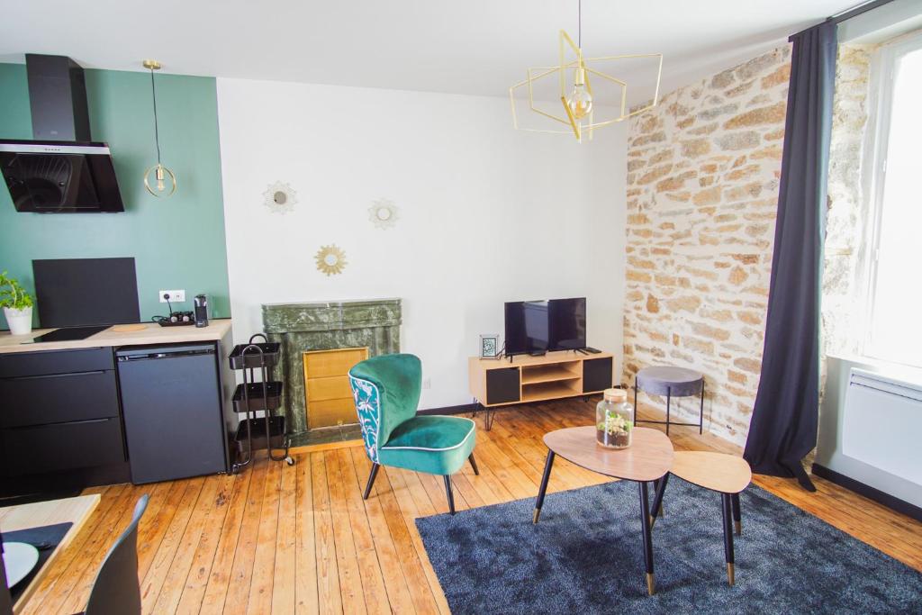 un salon avec une chaise verte et une table dans l'établissement -PICCO VERDE- Appartement avec balcon - Concarneau, à Concarneau
