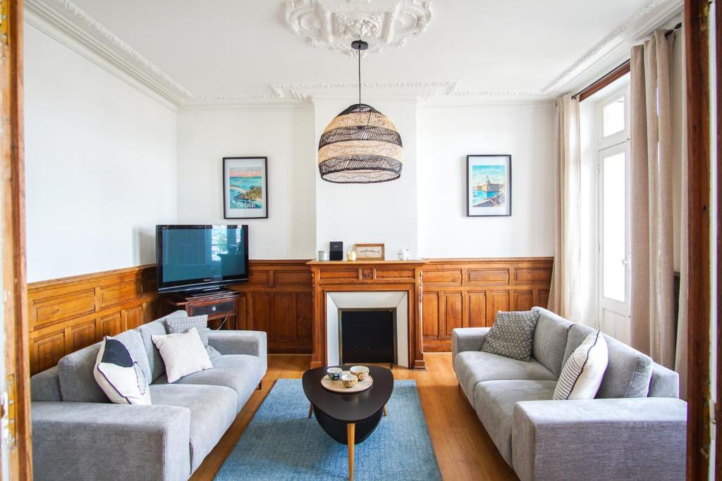 a living room with two couches and a tv at -BOSCO- Elegant T3 avec balcon et vue sur le port in Concarneau