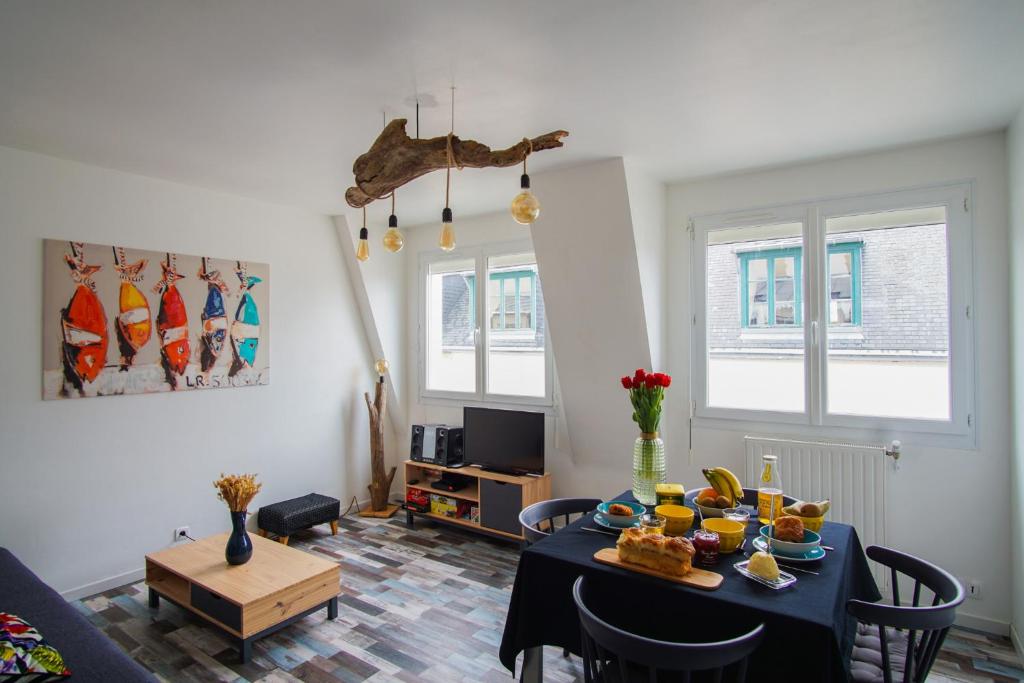 un salon avec une table avec de la nourriture dessus dans l'établissement -SKOL- Charmant T2, proche du centre de Concarneau, à Concarneau