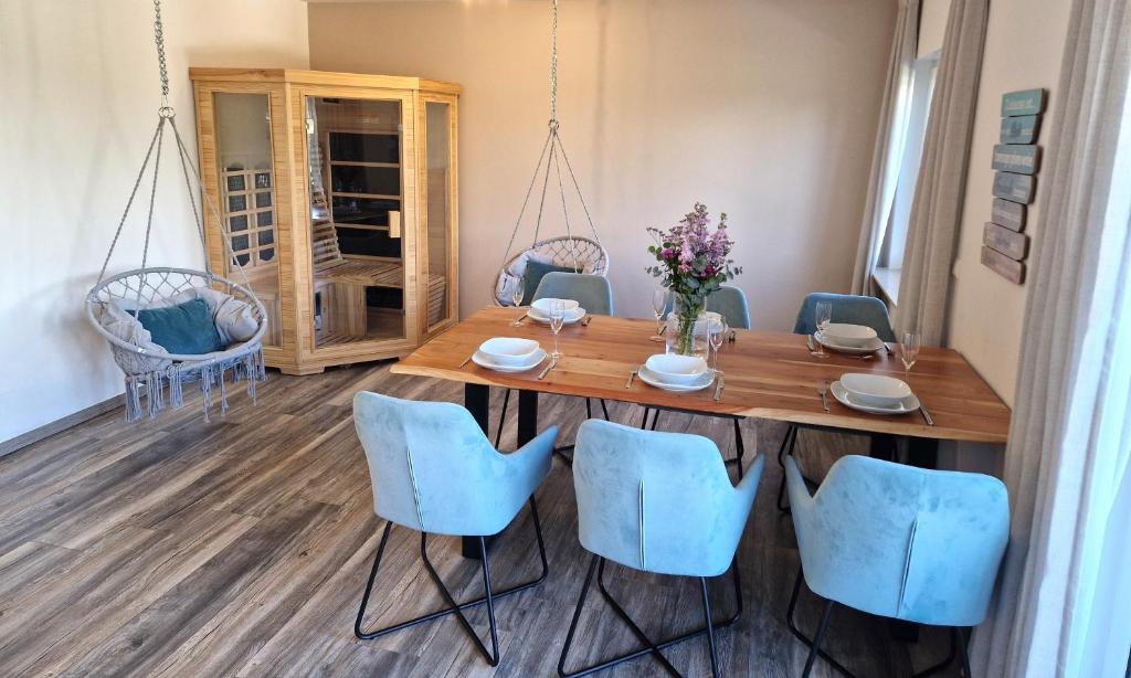 a dining room with a wooden table and blue chairs at Moderne Wohnung mit Sauna in Zülpich