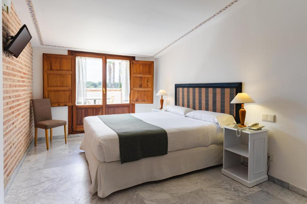 - une chambre avec un lit, une chaise et une fenêtre dans l'établissement Ad Hoc Parque, à Bétera