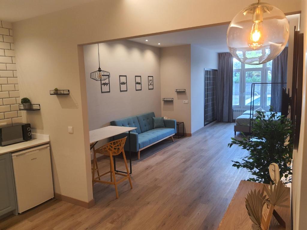 a living room with a blue couch and a table at Pensión CREDENCIAL in Sarria