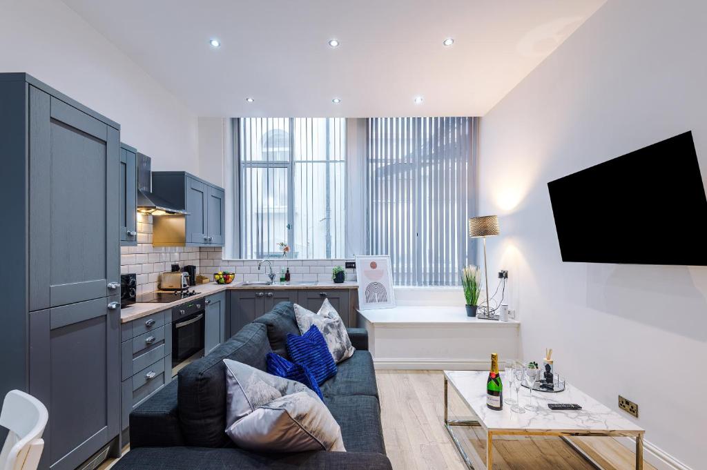 a living room with a couch and a kitchen at Modern 2-bedroom Apt In The Heart Of City Centre in Liverpool