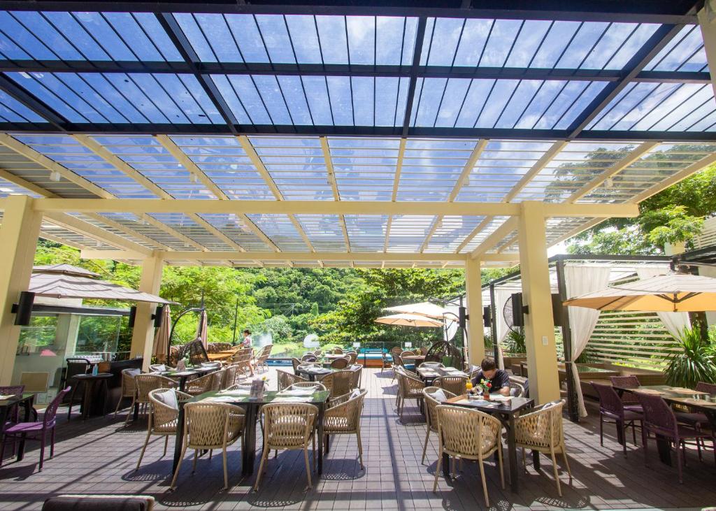 a patio with tables and chairs under a pergola at Fairways and Bluewater Boracay in Boracay