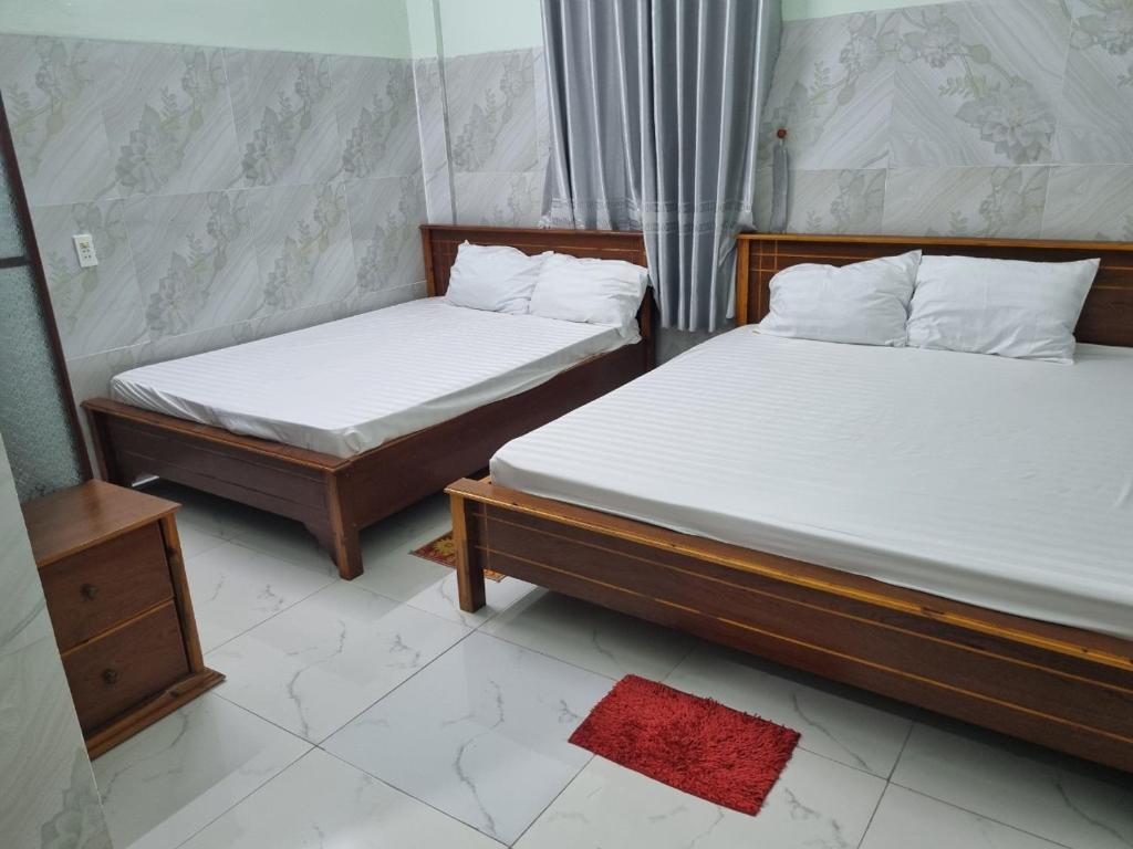 two twin beds in a room with at Khách sạn Ngọc Quỳnh in La Gi
