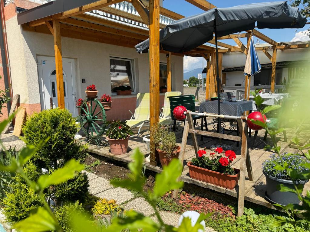 einen Garten mit einer Terrasse mit Pflanzen und einem Sonnenschirm in der Unterkunft Apartments Zupan in Šenčur