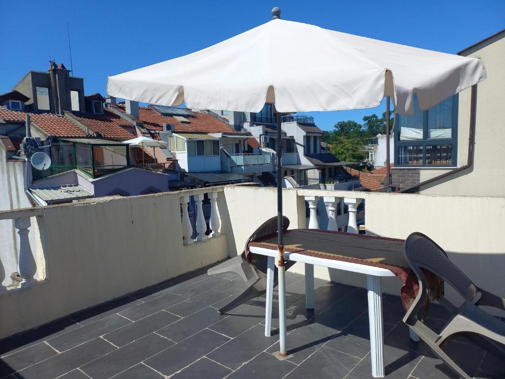 un parapluie blanc assis au-dessus d'un toit dans l'établissement Морска звезда Апартамент, à Bourgas
