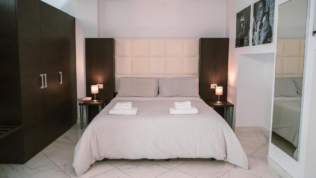 Morin 10 Rome Exclusive Suites في روما: غرفة نوم بسرير كبير مع مواقف ليلتين