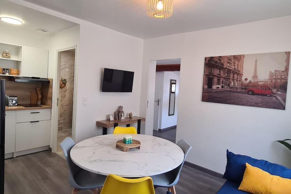 un salon avec une table et des chaises jaunes dans l'établissement Appartement scandinave au soleil, à Baillargues
