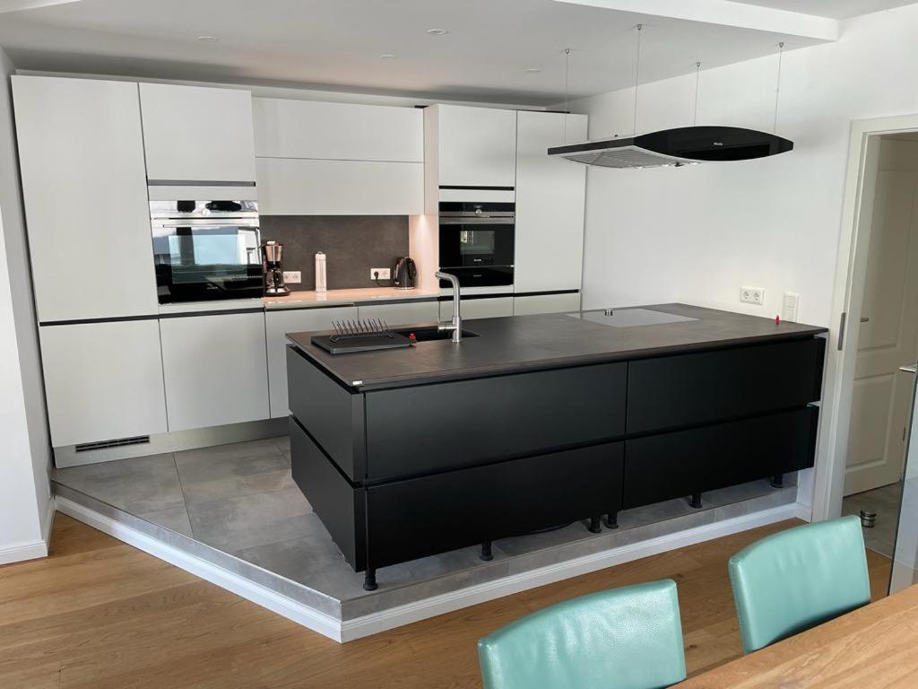 a kitchen with a black counter and white cabinets at Exklusives Apartment Nähe Attendorn und Olpe für 6 Personen mit Dachterasse in Attendorn