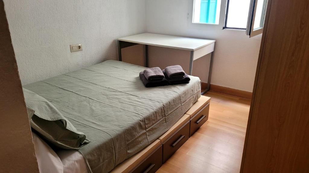 Habitación pequeña con cama y escritorio. en Apartment Turquesa - Almería, en Almería