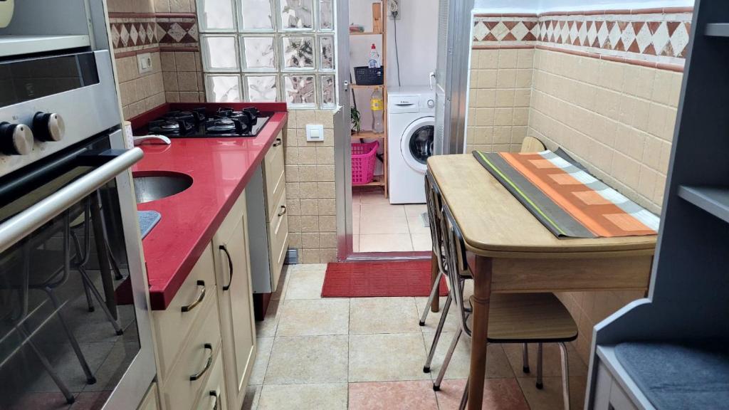 Una pequeña cocina con una encimera roja y un fregadero. en Apartment Turquesa - Almería, en Almería