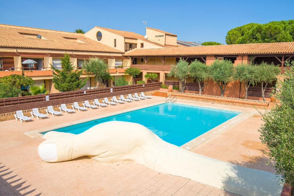 una gran piscina con una estatua blanca frente a un edificio en Lagrange Vacances Résidence du Golf en Saint-Cyprien