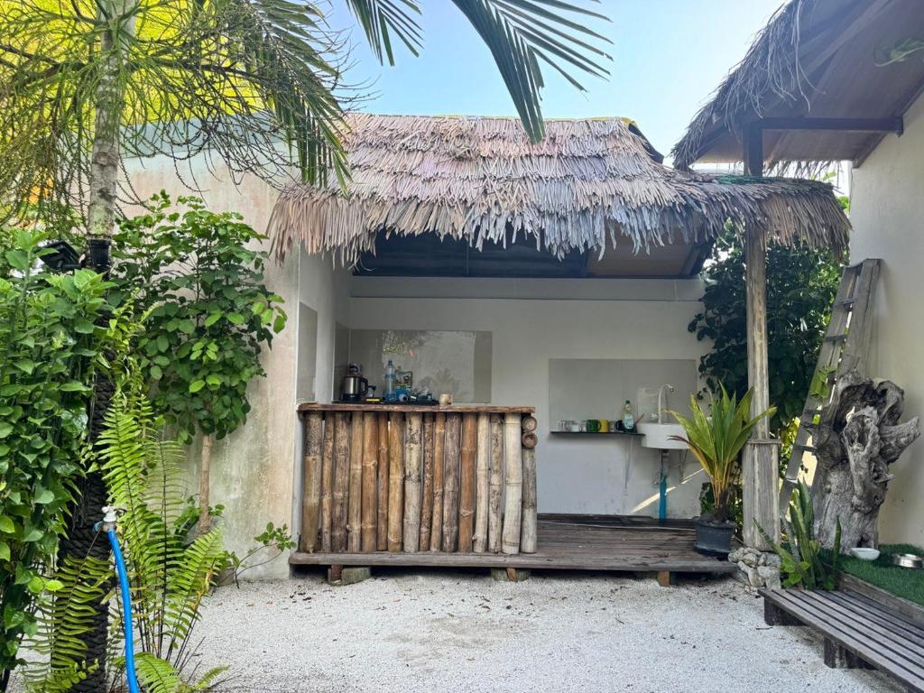 Casa pequeña con puerta de madera y porche en Oi Beach en Maamigili