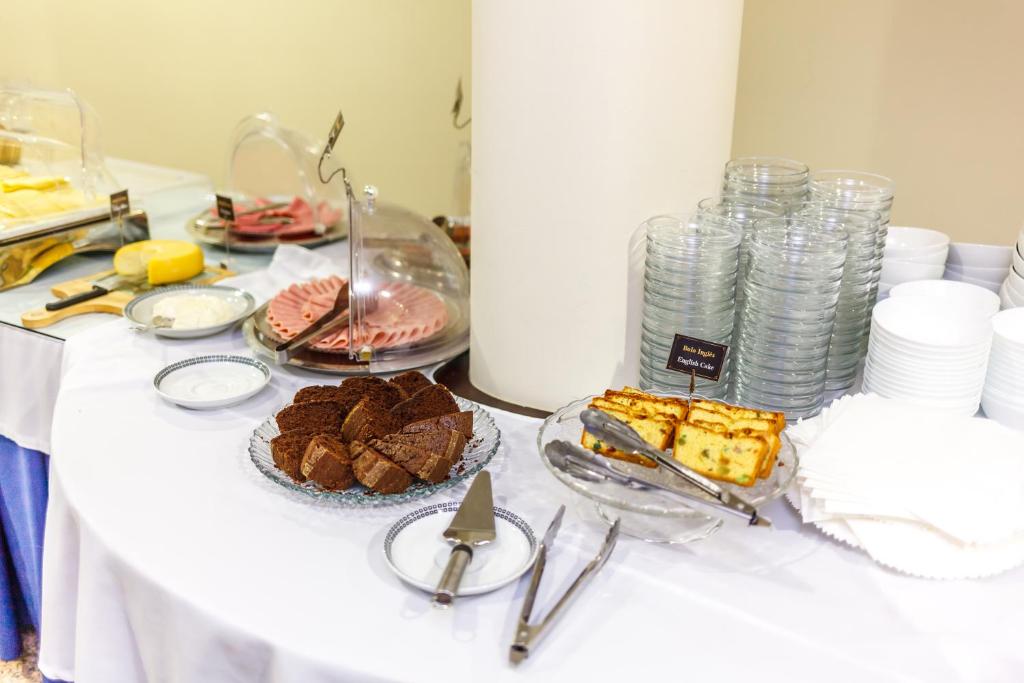 a white table with food and plates on it at Hotel Caravelas in Madalena