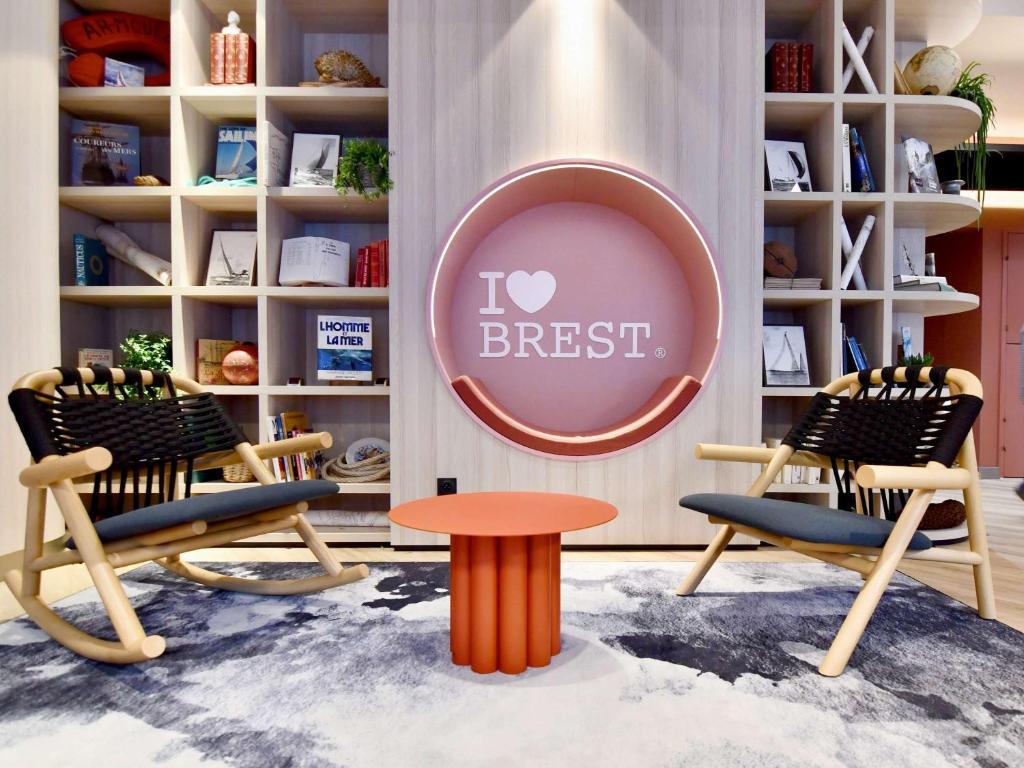 un magasin avec deux chaises et une table dans une pièce dans l'établissement ibis budget Brest Centre Port, à Brest