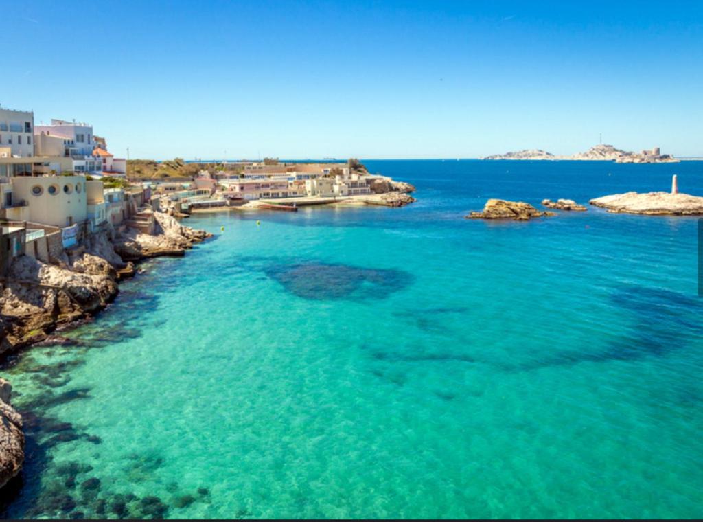 - une vue aérienne sur une plage d'eau bleue dans l'établissement Villa Malmousque avec accès mer privé, à Marseille
