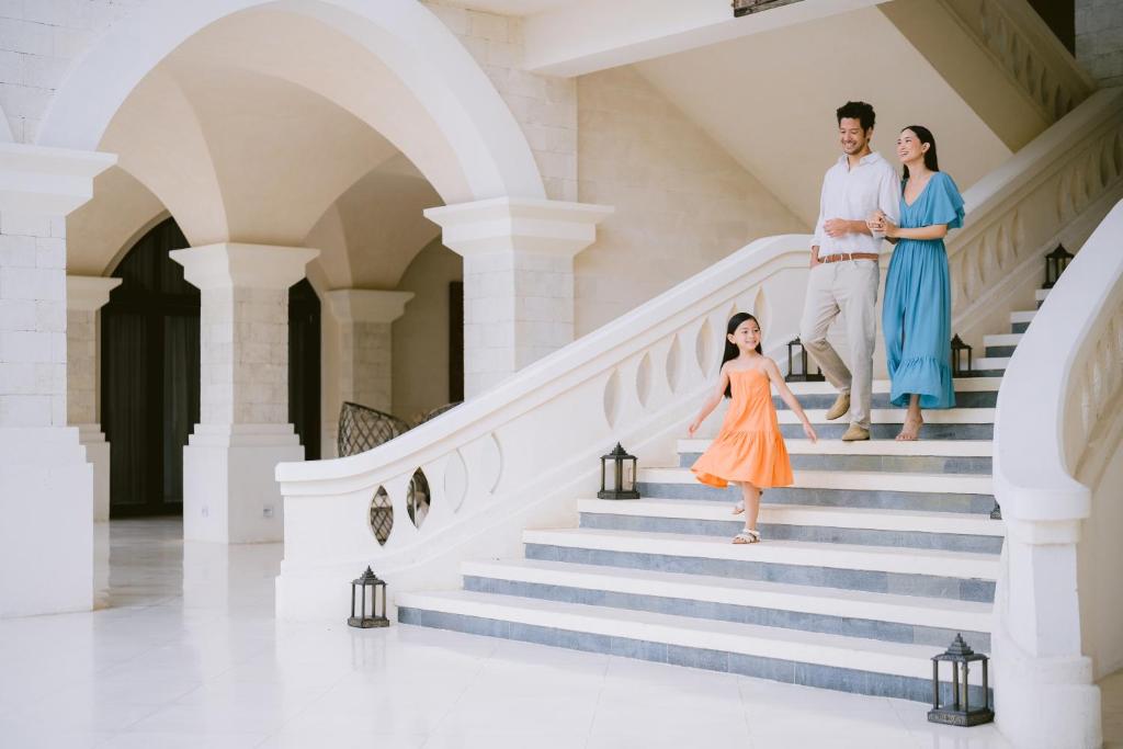 a family walking down the stairs of a house at Jumeirah Bali in Uluwatu
