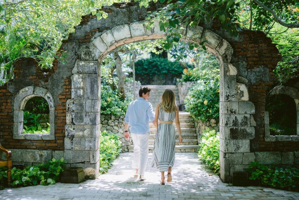 a man and a woman walking through an archway at Jumeirah Bali in Uluwatu