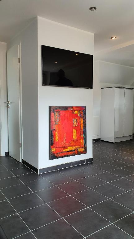 una camera bianca con un dipinto su un muro di City Lounge an der Feuerwache mit Außenbereich mit Klimaanlage a Wolmirstedt